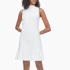 A Chic Choice, This Sleeveless Mini Dress Is Crafted With An Extra Soft Stretch Blend. Features A Mock Neckline, A V-Back With Tie Straps And A Ruffle Hem. A-line Sleeveless Dress With Ruffles For Daywear, Feminine Sleeveless Stretch Mini Dress, Feminine Sleeveless Mini Dress For Work, Sleeveless Mini Dress With Ruffle Hem, Sleeveless Ruffle Hem Dress For Daywear, White Sleeveless Mini Dress With Ruffle Hem, White Sleeveless Dress With Ruffle Hem, Ruffled Sleeveless Dress For Workwear, Stretch Sleeveless Mini Dress With Ruffles