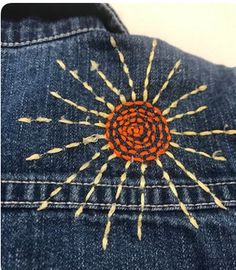 an embroidered sunburst on the back of a jean jacket