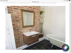 an image of a bathroom setting with brick wall and white bathtub, sink and mirror