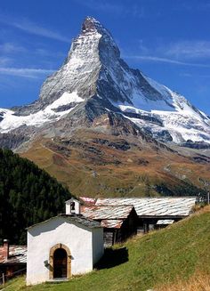 a mountain is in the background with a small building