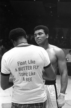 two men standing next to each other in front of a basketball court with the words float like a butter fly sting like a bee on their back