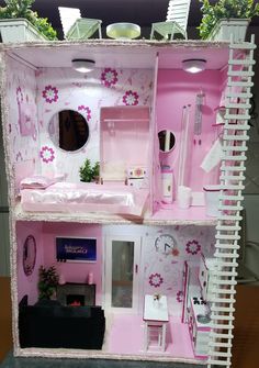 a doll house with pink furniture and flowers painted on the walls is shown in full view