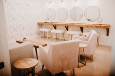 chairs and tables in a room with mirrors on the wall behind them, along with other furniture