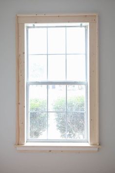 an empty window in a white room with no curtains on the windowsill and bare wood framing