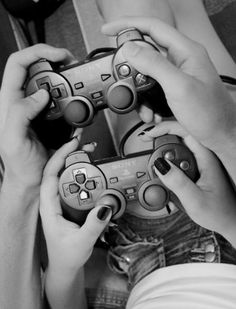 two people holding video game controllers in their hands