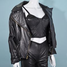 "Vintage 80s soft black leather motorcycle jacket. Zippers up the front, on the pockets, and wrist. Loose fit, wide shoulders. **Purple studded belt is NOT included in this sale. It is for styling purposes only. LABEL: Cache SIZE: All sizing given is approximate. Refer to measurements for an accurate fit. Shoulder: 20\" Underarm: 22\" double to 44\" Sleeve: 22 1/2\" Waist: 17 1/2\" double to 35\" Length: 21\" Mannequin measurements: Size 2, Bust - 33\" Waist - 24\" Hips - 34\" CONDITION: Very go Goth Rave, 80s Punk, Black Leather Motorcycle Jacket, Wide Shoulders, Leather Jacket Style, Studded Belt, Grunge Goth, Leather Motorcycle Jacket, Moto Jacket