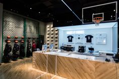 the inside of a sports shop with basketballs and t - shirts on display