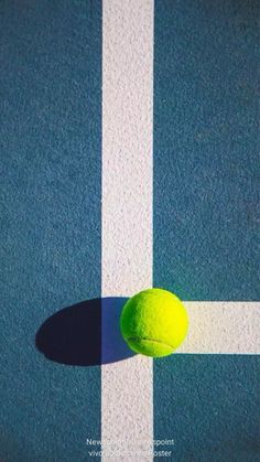 a tennis ball sitting on top of a blue and white court