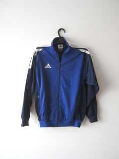 "Vintage Blue Adidas Jacket Blue Adidas Zipper Running Jacket Unisex Jogging Parka Blue Soccer Jacket Three Stripes Size Large Adidas Cardigan Label size: D 176; GB 34/36; F 16A Measurements: (lying flat) Length - 28.5\"/ 72.5 cm Shoulders: 20\"/ 51 cm Pit to pit: 22.5\"/ 57 cm Waist: 19.5\"/ 49.5 cm Sleeve: 22.5\"/ 57 cm Please check measurements to insure a proper fit. Remember to allow yourself some extra room for movement. You can compare these with something from your closet that fits you w Blue Long Sleeve Outerwear With Zipper Closure, Blue Long Sleeve Outerwear With Zipper, Casual Blue Windbreaker With Zipper, Casual Blue Windbreaker With Zipper Closure, Blue Windbreaker With Zipper Closure For Fall, Blue Windbreaker With Zipper For Fall, Blue Zipper Windbreaker For Fall, Winter Blue Windbreaker With Zipper Closure, Blue Zipper Closure Windbreaker For Fall