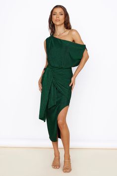 a woman wearing a green dress with one shoulder tied around the waist and an asymmetric