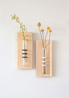 two vases with flowers in them are on the wall, one is made out of wood