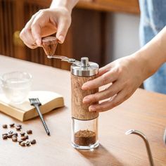 a person is using a grinder to make something out of a coffee cup on a table