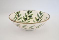 a white bowl with olives painted on it