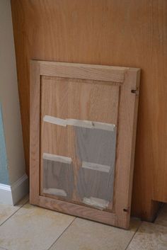 a wooden frame with two pieces of glass in it on the floor next to a wall