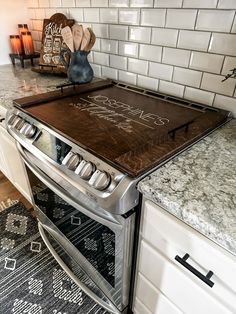 a stove top oven sitting inside of a kitchen next to a counter with a chalkboard on it