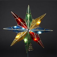 a multicolored stained glass star ornament on a metal stand with wire