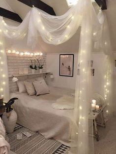 a bedroom with white lights on the ceiling and curtains over the bed in front of it