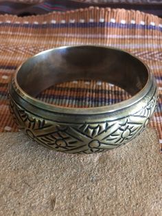 Vintage brass bracelet has silver plating on inside and over edge. Beautiful tribal design will look nice to offset black attire or blend well with Southwest or other ethnic clothes. Inside of bangle measures 8 inches around. It is 1 1/4 inch wide and about 1/2 inch high. A fun boho vintage bracelet. Would make an unique gift. Metal Bangle With Intricate Design For Festival, Brass Bangle With Intricate Design For Rituals, Bohemian Brass Round Bracelets, Bohemian Round Brass Bracelets, Ritual Bangle With Intricate Design In Brass, Ritual Bangle With Intricate Brass Design, Bohemian Metal Bracelets With Antique Finish, Bohemian Metal Bracelet With Antique Finish, Bohemian Round Cuff Bracelet For Festivals