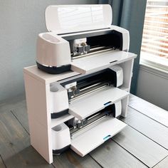 a white printer sitting on top of a wooden table