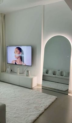 a flat screen tv mounted to the side of a wall next to a white couch