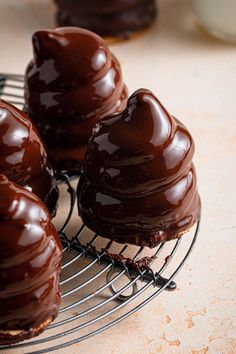 chocolate covered donuts sitting on a wire rack