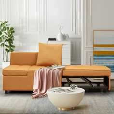 a living room with an orange couch and white vase on the floor next to it