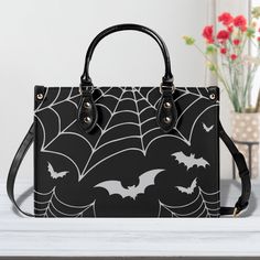 "Available in three sizes, this Gothic Spiderweb and Bats Purse is the perfect accessory for anyone who loves spooky and stylish fashion. Crafted from vegan materials, this black handbag features a spiderweb and bat design that is sure to turn heads. With a spacious size (11, 13 or 16 inch), this purse is ideal for carrying all your essentials. Whether you're heading to a Goth party or just want to add a touch of dark flair to your everyday look, this Spooky Black Handbag is the perfect choice. Black Tote Shoulder Bag For Halloween, Black Halloween Shoulder Bag Satchel, Halloween Black Shoulder Satchel, Black Halloween Rectangular Shoulder Bag, Black Rectangular Shoulder Bag For Halloween, Black Shoulder Satchel For Halloween, Black School Bag For Halloween, Black Shoulder Bag Satchel For Halloween, Black Satchel Shoulder Bag For Halloween