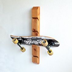 a skateboard mounted to the side of a white wall next to a wooden cross