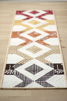 a quilted table runner on a wooden floor