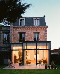 a brick house with glass walls and lots of windows