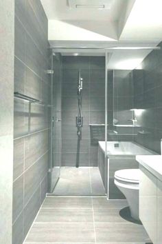 a bathroom with a toilet, sink, and shower stall in black and white photo