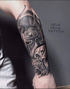 a man's arm with a tattoo on it and a spartan helmet in the middle