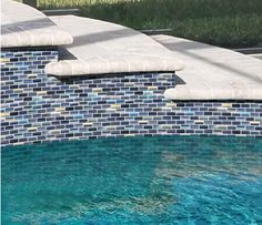 an empty swimming pool with blue tiles on the wall and water running down it's sides