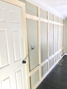 an empty room with white walls and wood trim around the doors, which are being installed