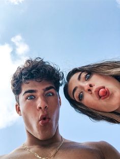 a man and woman making funny faces while standing next to each other in front of a blue sky