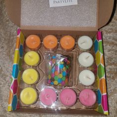 a box filled with lots of different colored candles