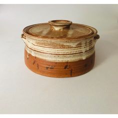 a brown and white ceramic covered dish on a table