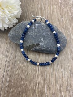 "Handcrafted dark blue and silver beaded bracelet made from Lapis lazuli gemstones and sterling silver. The perfect gift for a loved one or to treat yourself. Women's Sizes: 6.5\" - Petite 7.0\" - Small 7.5\" - Medium 8.0\" - Large Men's Sizes: 7.0\" - Petite 7.5\" - Small 8.0\" - Medium 8.5\" - Large (For further help with sizing or custom sizing requests, send us a message.)" Blue Sterling Silver Bracelet With Round Beads As Gift, Blue Beaded Bracelets With Sterling Silver Gemstone Beads, Silver Lapis Lazuli Bracelet, Hand-strung, Silver Lapis Lazuli Hand-strung Bracelets, Silver Hand-strung Lapis Lazuli Bracelet, Adjustable Blue Sterling Silver Bracelet With Silver Beads, Silver Lapis Lazuli Beaded Bracelets For Healing, Blue Beaded Sterling Silver Bracelet, Blue Sterling Silver Bracelets With Gemstone Beads