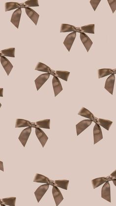 many brown bows are flying in the air on a light pink background with small white dots