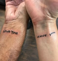 two people with matching wrist tattoos that say love you