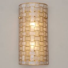 a wall light that is mounted to the side of a wall with a white and gold weave pattern on it