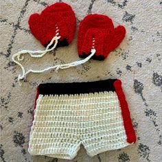 a crocheted pair of shorts and mittens are laying on the floor next to each other