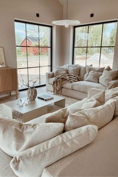 a living room filled with furniture and large windows