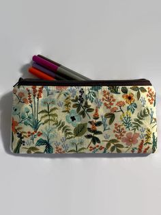 "This listing has six options to choose from. All pouches are made with a high quality Rifle Paper fabric print on the outside.  Interfaced for stability. Secured with a quality zipper. The inside is lined with 💯 cotton fabric. Dimensions: 9\" in length x 5\" in length. Perfect as a pencil case, cosmetics case, cash holder or accessory pouch.  Care: wash in a gentle cycle using cold water and air dry for best results.  Thank you for visiting Gratitude Oasis." Cotton Pencil Case, Gift Organizer With Zipper, Rectangular Craft Case With Pen Slots For Daily Use, Rectangular Craft Supplies Case With Pen Slots, Multicolor Craft Supplies Pen Holders For Daily Use, Multicolor Craft Supplies With Pen Holders For Daily Use, Pouch Pencil Case With Pen Holders For Personal Use, Pouch Cases With Pen Holders For Daily Use, Pencil Case With Pen Holders For Personal Use