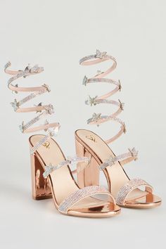 a pair of high heeled sandals with straps and crystal embellishments on the toes