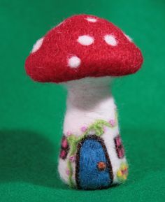 a small red mushroom sitting on top of a green surface