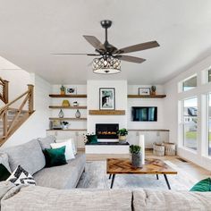 a living room filled with furniture and a fire place next to a stair case in front of a window