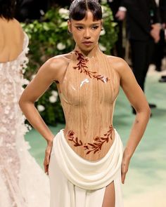 a model walks down the runway in an unusual dress