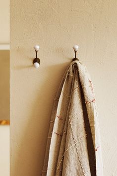 a towel hanging on the wall next to a coat rack