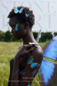 a woman with blue butterflies painted on her body and wings, standing in a field